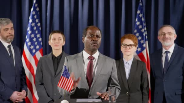 Афроамериканский Президент Стоит Трибуне Американским Флагом Ней Выступает Микрофон Делая — стоковое видео