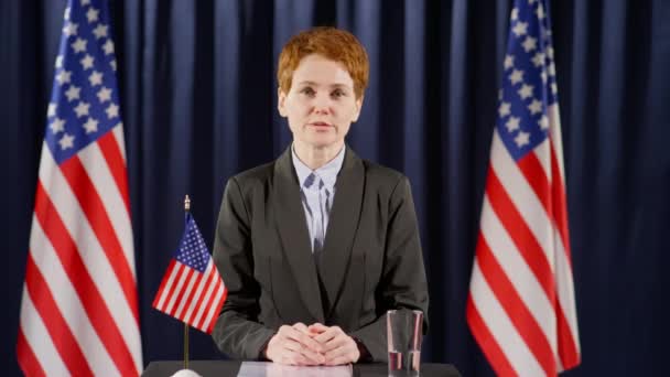 Una Mujer Política Mirando Cámara Dando Discurso Tribuna Con Bandera — Vídeos de Stock