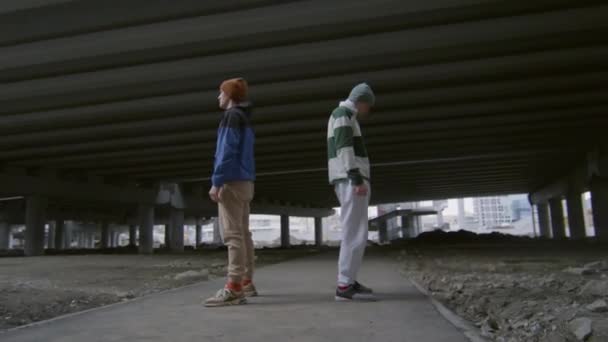 两名身穿运动服的年轻人在城市街道上慢动作地表演史诗般的公园侧影时的弧形镜头 — 图库视频影像