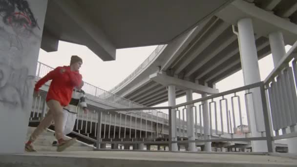 两名年轻的公园运动员同时侧身翻滚 然后在城市楼梯上摆姿势拍照 — 图库视频影像