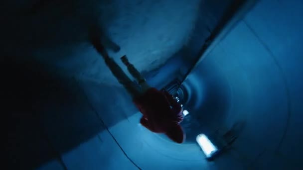 青いネオンと暗い地下トンネルを通って実行している駐車場のシネマティックカメラロールショット — ストック動画