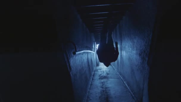 暗い廊下を通って光に向かって2階に実行されているパルクール選手のカメラロールショット — ストック動画