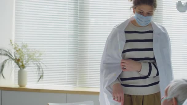 Frau Mit Schutzmaske Und Laborkittel Geht Auf Krankenhausstation Hält Hand — Stockvideo