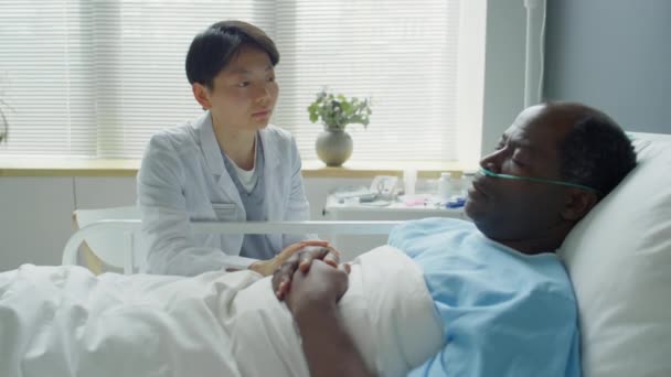 Zoom Out Shot Concerned Asian Female Doctor Sitting Bedside Hospital — Vídeo de Stock