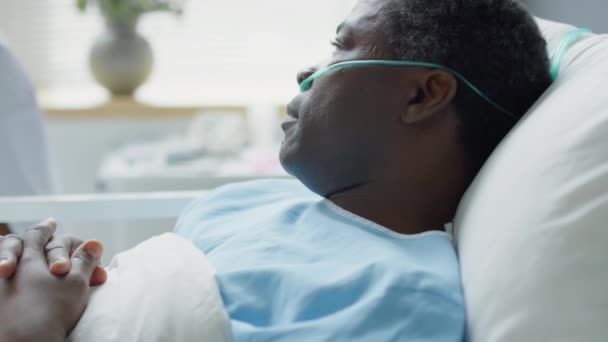 在医院病房里躺在床上 与妻子和亚洲女医生交谈的非洲裔美国男人的倾斜镜头 — 图库视频影像