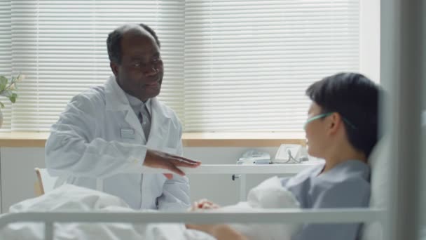 Zooma Fotograferad Mogen Afroamerikansk Läkare Sittande Vid Sängkanten Sjukhusavdelningen Och — Stockvideo