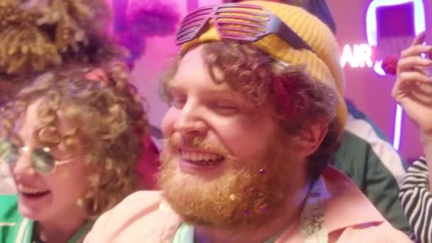 Mann Mit Bart Und Party Sonnenbrille Sitzt Mit Freunden Vor — Stockvideo