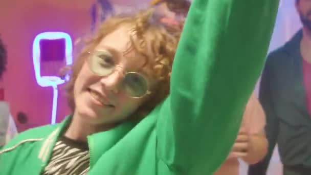 在迪斯科舞会上 身穿90年代艳丽服装 戴着绿色时髦太阳镜的快乐女孩在镜头前与朋友们跳舞微笑 — 图库视频影像