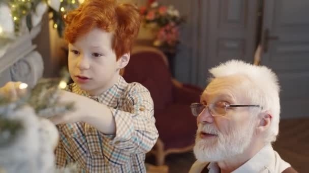 Niño Con Pelo Jengibre Decorando Árbol Navidad Casa Hablando Con — Vídeos de Stock