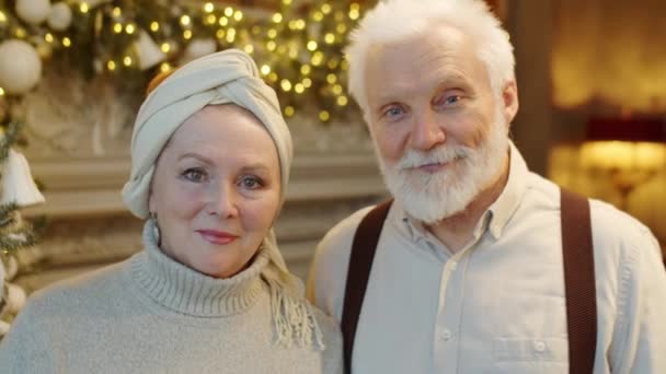 Portrett Seniorpar Som Står Ved Juletreet Rom Dekorert Med Lys – stockvideo