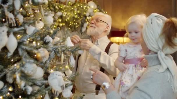 Anciano Decorando Árbol Navidad Casa Como Esposa Sosteniendo Adorable Nieta — Vídeos de Stock