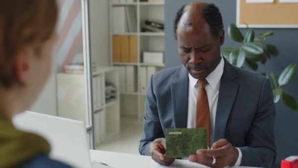Afroamerikanische Konsularbeamte Überprüfen Während Eines Interviews Der Botschaft Den Pass — Stockvideo