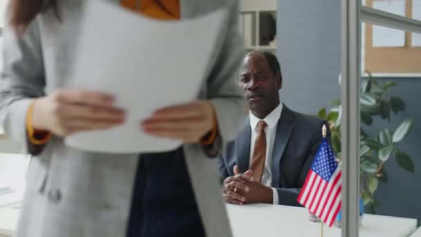 African American Visa Officer Genomför Intervjuer Och Kontrollera Handlingar Sökande — Stockvideo