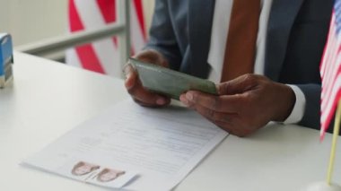Afrika kökenli Amerikalı erkek vize memurunun ABD elçiliğindeki belgelerle uğraşırken reddedilen pulu başvuru formuna yapıştırdığı yakın plan.