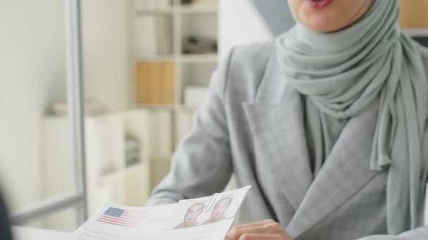 米国大使館でのビザ面接中に領事と話すヒジャーブ州の若いイスラム教徒の女性 — ストック動画