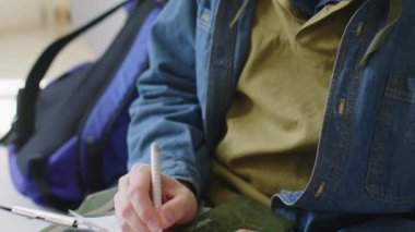 Elçilikteki görüşme öncesinde genç beyaz adamın vize başvurusu formunu doldururken yakın plan çekimleri.