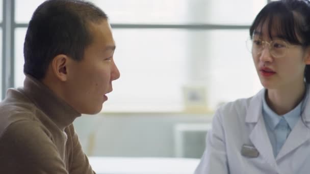 Aziatische Vrouwelijke Arts Hebben Discussie Met Mannelijke Patiënt Tijdens Gezondheidsoverleg — Stockvideo