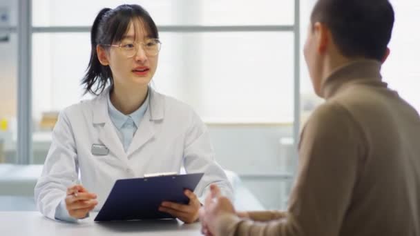 Кадре Изображена Азиатская Женщина Врач Приветствующая Пациента Мужчину Идущего Медицинский — стоковое видео