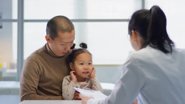 Ázsiai Férfi Kisgyermek Lánya Klinikán Így Kórtörténet Női Gyermekorvos Beszél — Stock videók
