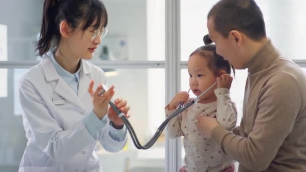 Fröhliche Asiatische Kinderärztin Und Entzückendes Kleinkind Mädchen Das Mit Stethoskop — Stockvideo