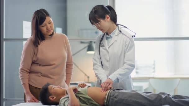 Asiático Feminino Pediatra Palpitante Estômago Tween Menino Falando Com Sua — Vídeo de Stock