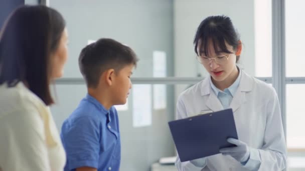 아시아 소아과 의사가 상담중에 클립보드에 처방을 계획을 설명하는 — 비디오
