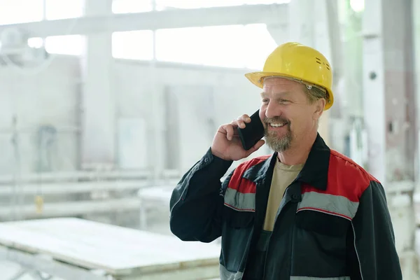 Maturo Ingegnere Sorridente Avendo Conversazione Sul Telefono Cellulare Mentre Lavora — Foto Stock