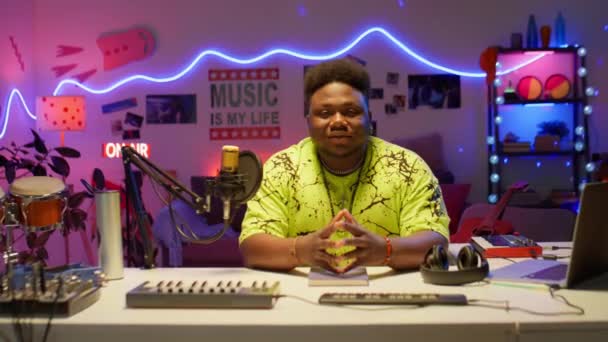 Портрет Афроамериканского Музыканта Позирующего Перед Камерой Сидящего Столом Записывающим Оборудованием — стоковое видео