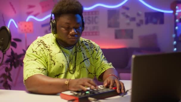 Africký Americký Hudebník Sluchátkách Pomocí Notebooku Audio Mixéru Při Práci — Stock video