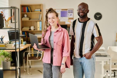 Bilgisayarda çalışırken ve bilişim ofisinde kameraya gülümseyen meslektaşlarımın portresi