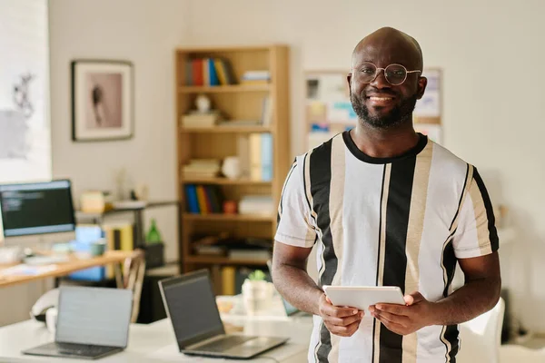 オフィスのタブレットPc上で作業しながら カメラで笑顔眼鏡でアフリカ系アメリカ人プログラマーの肖像画 — ストック写真