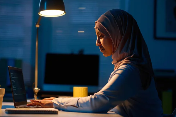 stock image Side view of muslim woman working online on laptop in office during deadline