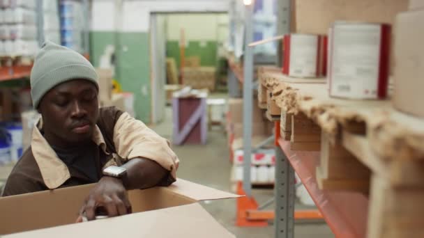 Ein Afroamerikanischer Arbeiter Nimmt Farbdosen Aus Dem Regal Und Legt — Stockvideo
