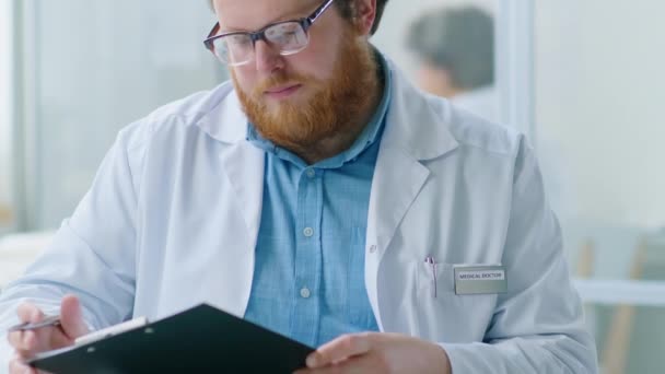 Naklonit Záběr Vousatého Lékaře Bílém Plášti Brýlích Čtení Dokumentu Schránce — Stock video