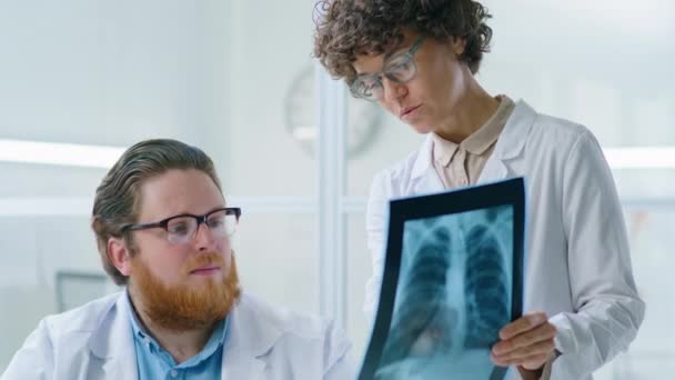 Tilt Shot Male Doctor Discutiendo Radiografía Tórax Con Colega Mientras — Vídeo de stock