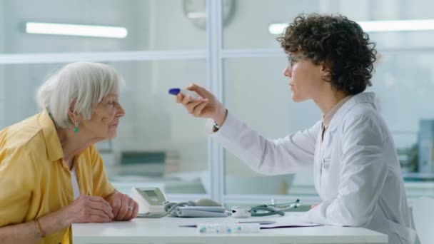 Kvinnlig Läkare Mäta Temperaturen Eldelry Kvinna Med Infraröd Termometer Medicinsk — Stockvideo
