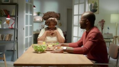 Afro-Amerikalı çiftin evde yemek yemeden önce konuşmalarını ve dua etmelerini yakınlaştırın.
