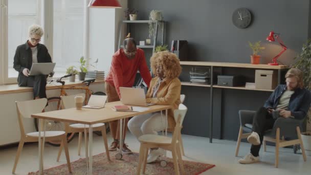 아프리카 미국인 사업가가 근무하는 사무실에서 일하는 동료와 노트북 화면으로 프로젝트에 — 비디오