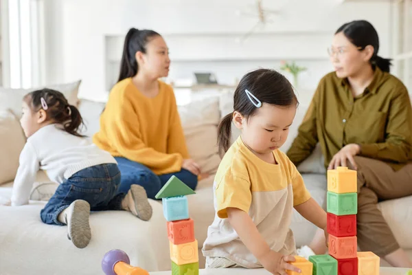 Děti Hrají Hračky Zatímco Jejich Matky Mluví Pozadí Obývacím Pokoji — Stock fotografie