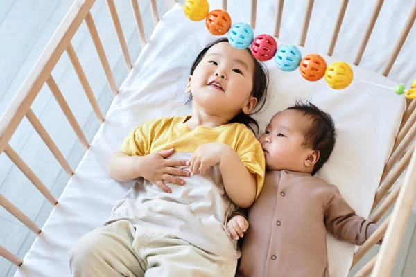 침대에 누워서 장난감을 가지고 아시아의 귀여운 어린이들의 — 스톡 사진