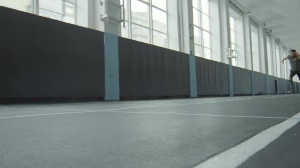 男子假肢短跑运动员在室内体育场训练时的地面慢动作射击 — 图库视频影像
