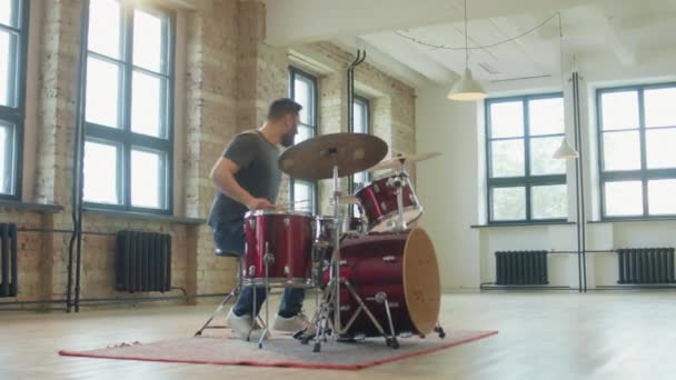 プロの男性ドラマーがスタジオを歩き リハーサル中にドラムを演奏する — ストック動画