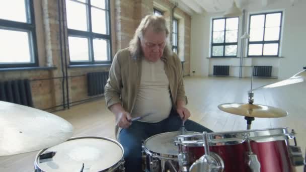 灰色の髪を持つシニアプロのミュージシャンは 音楽リハーサルスタジオでワイヤーブラシでドラムを演奏 — ストック動画
