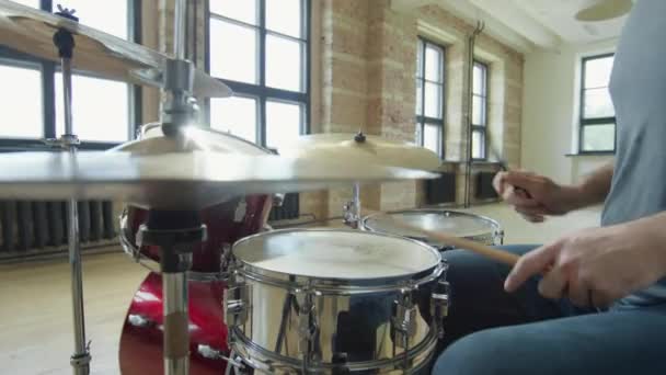 スタジオでリハーサルでドラムキットを演奏プロの男性ミュージシャンのトリミングショット — ストック動画