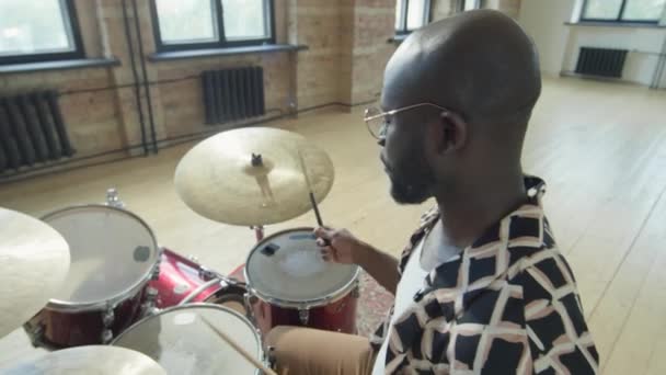 アフリカ系アメリカ人プロの音楽家 ドラムスティックでドラムを演奏しながら音楽リハーサルスタジオで作業する角度の高い眺め — ストック動画