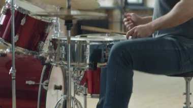 Stüdyo provası sırasında bateri ve pedal kullanan beyaz erkek davulcuyu yukarı kaldır.