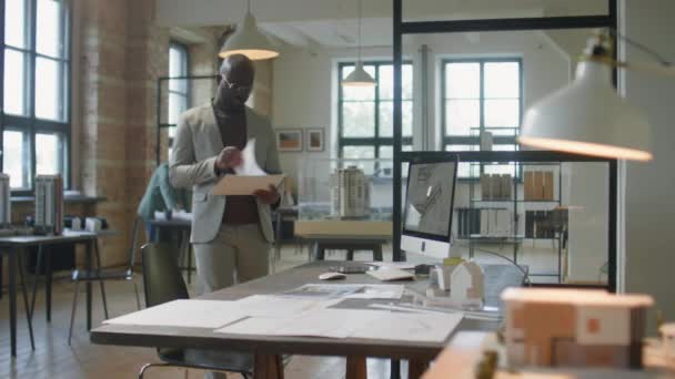 Afroamerikanischer Männlicher Architekt Läuft Büro Seinem Arbeitsplatz Liest Zeitung Und — Stockvideo