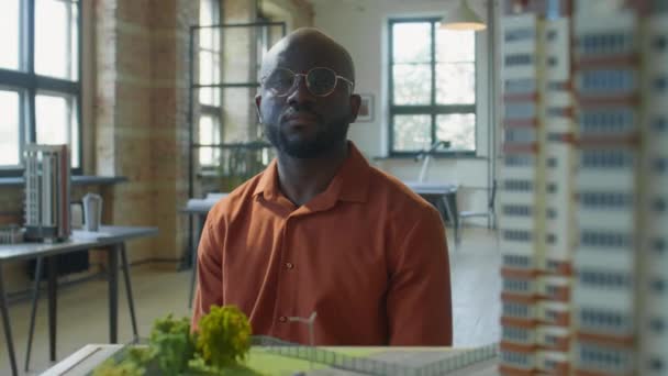 Portret Afroamerykanina Męskiego Architekta Siedzącego Według Modelu Budynku Mieszkalnego Pozującego — Wideo stockowe