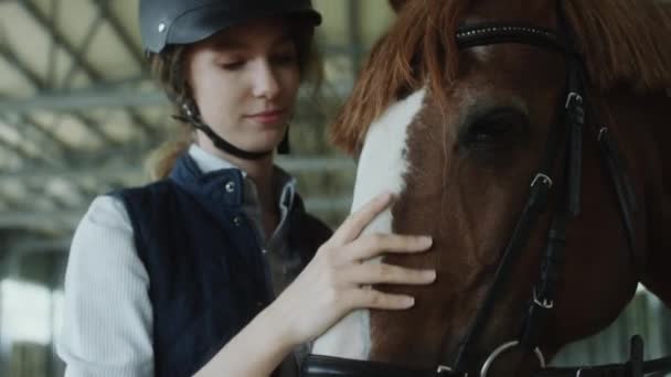 Porträt Der Schönen Jockeyspielerin Mit Helm Streichelt Pferd Und Posiert — Stockvideo