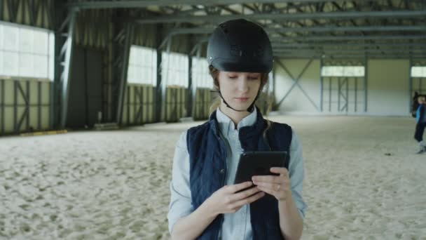 말타기 경기장에서 디지털 태블릿을 사용하여 헬멧을 기수의 사진을 흔들어 — 비디오
